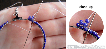 String a single bead onto the thread and slide the needle underneath the next thread bridge connecting the beads at the bottom