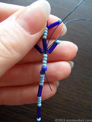 Push the wire towards the centre so that you come out in between the large seed beads