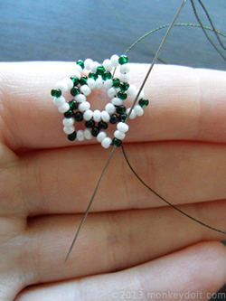 Go through the beads in front of the needle so that you come out through the uppermost bead