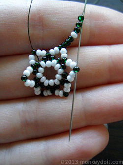 Push the needle through the most protruding bead from the row below