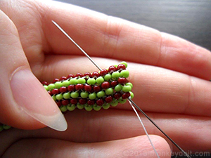 Bring the needle up through a couple of beads to bury the knot inside