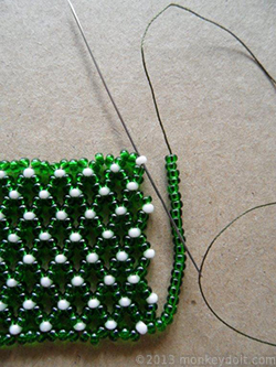 String as many beads as you need to reach the opposite end of the row and push the needle through bead A