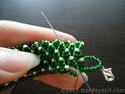 Weave the thread through a couple of beads in any direction to bury the knot and cut the remaining thread as close to the beads as possible