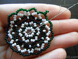 Weave the thread through a couple of beads in any direction to bury the knot