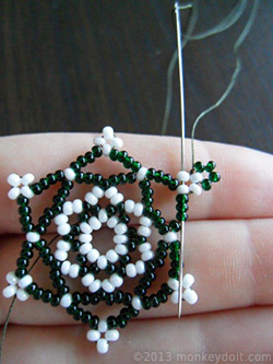 Weave the thread through several beads to bury the knot and cut the thread end as close to the beads as possible