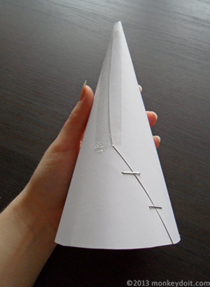 Form a cone out of cardboard for the Christmas tree. Secure the bottom with staples and the top with scotch tape