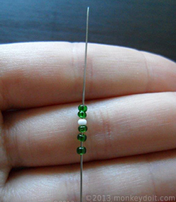 three green beads followed by one white bead, then two green beads