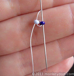 needle back down through the second earring bead