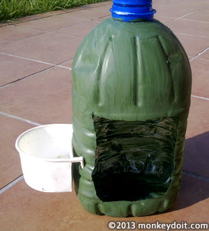 Plastic bottle bird house with bird bowl attached