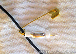 An open safety pin with beads