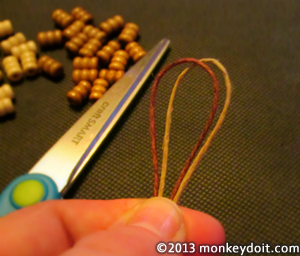 Line up and fold the two pieces of hemp cord in half