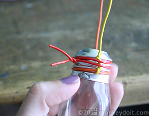 Another colored wire added to the silver base of the lightbulb vase
