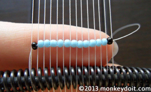 Fit the beads into the spaces between the warp threads